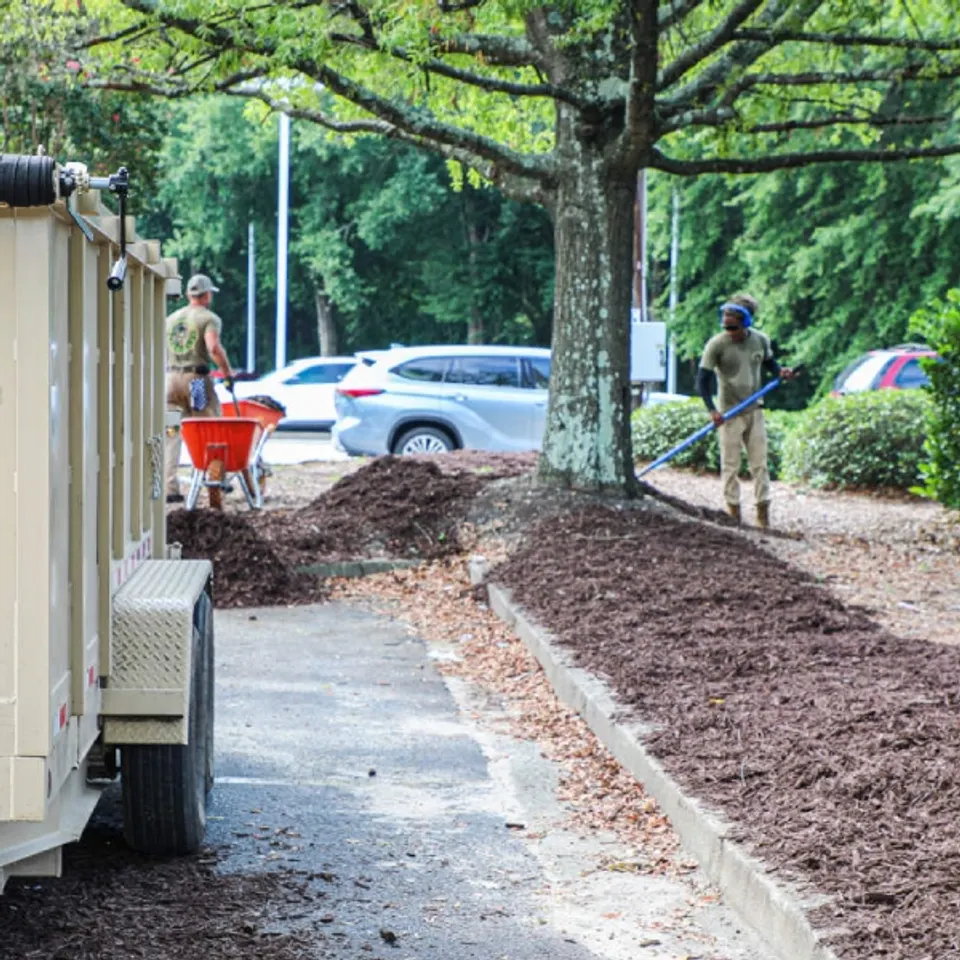 Crew refreshing mulch and cleaning landscape beds